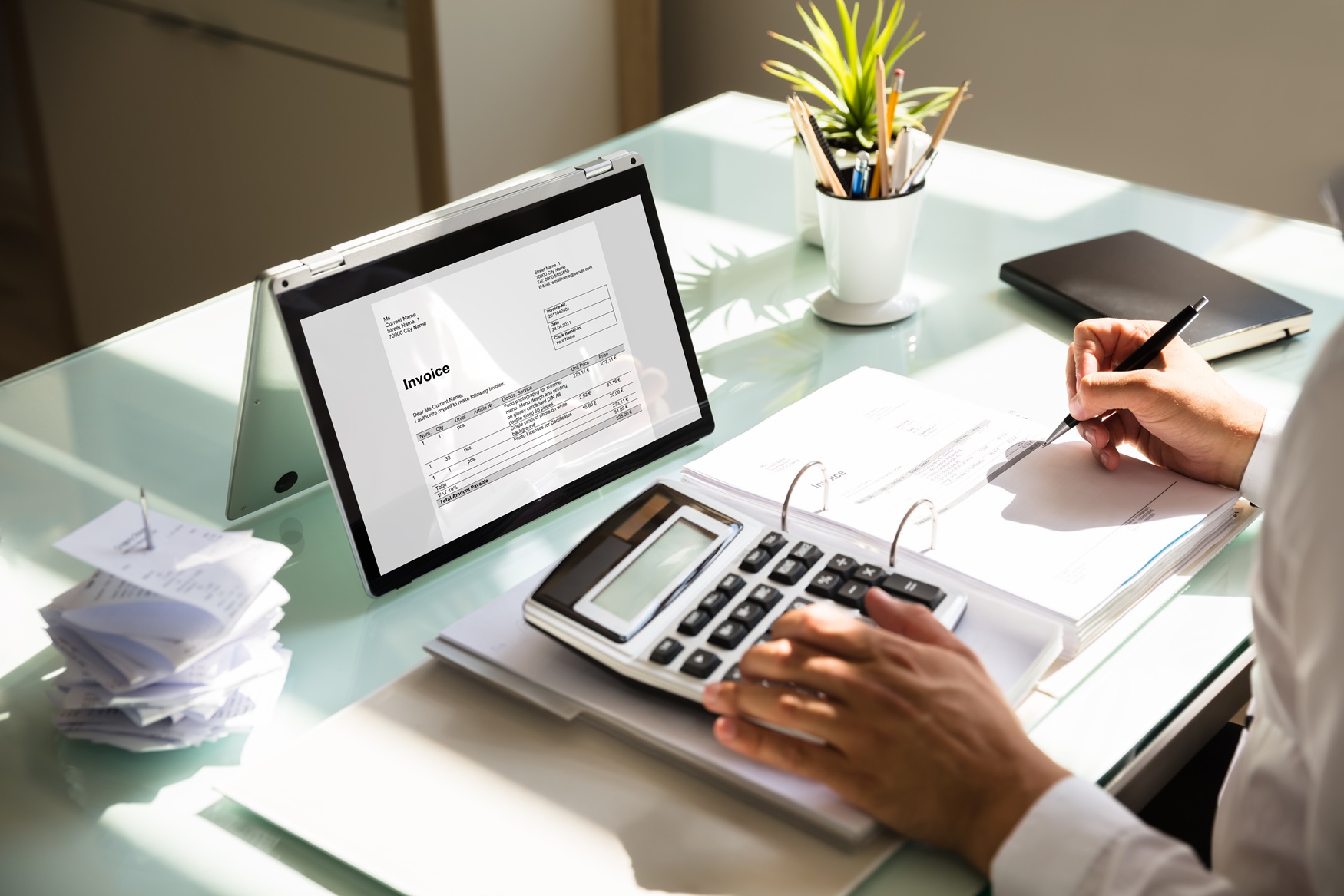 Businessman calculating invoice using calculator